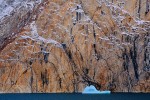 Melting iceberg and rock face with desert varnish, Ofjord
